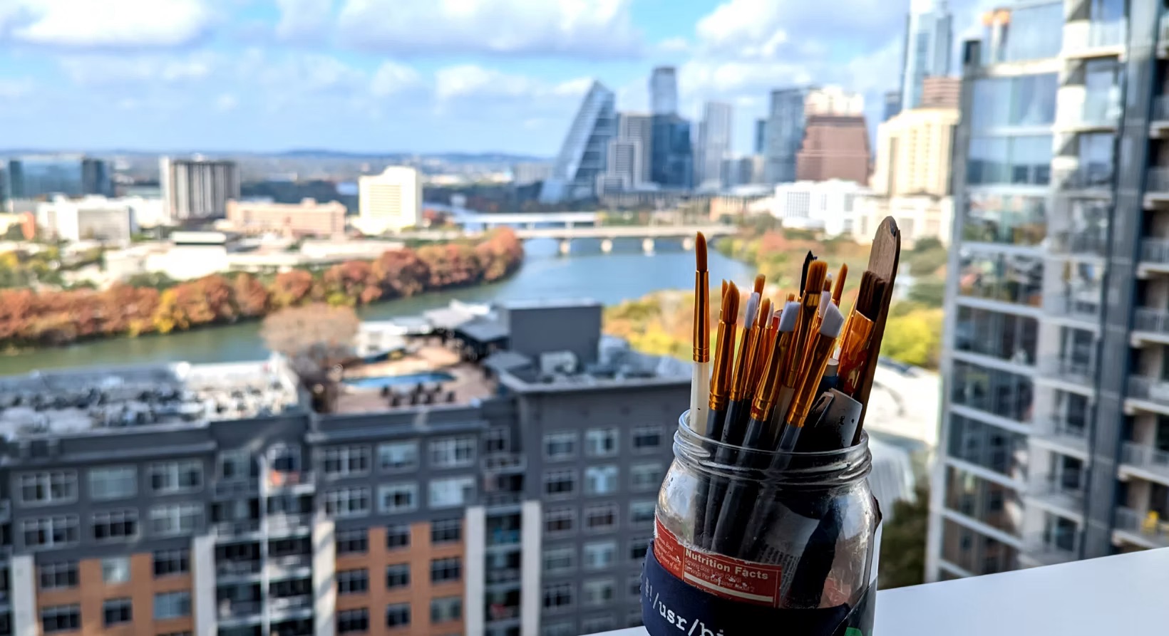 Austin skyline beyond a jar of artists' brushes